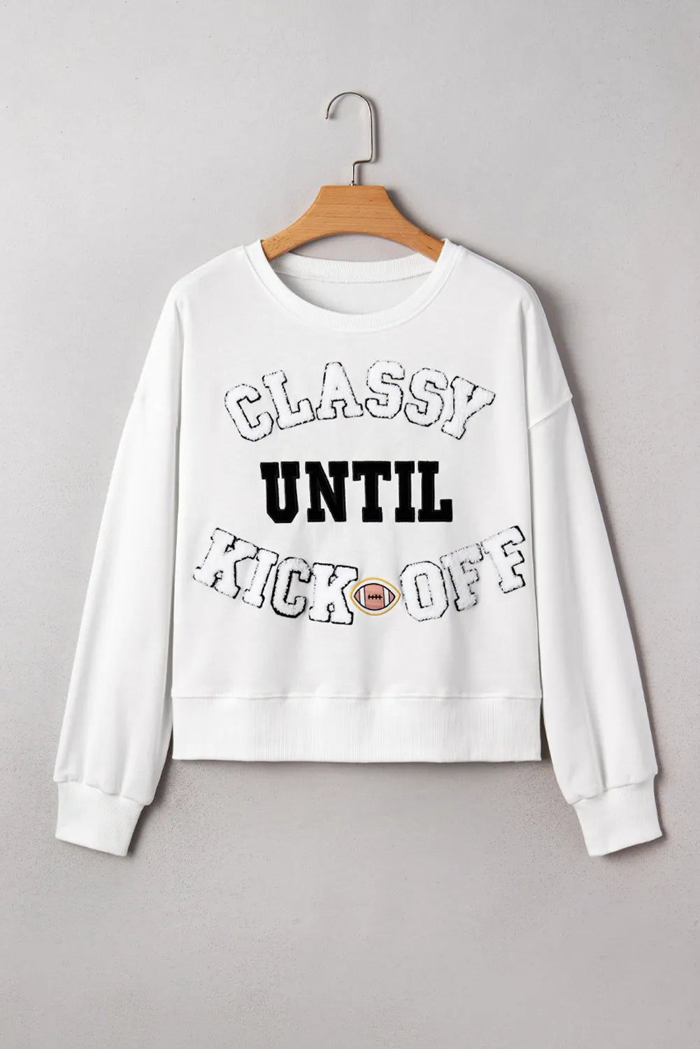 White sweatshirt with 'Classy Until Kick Off' text on a gray background