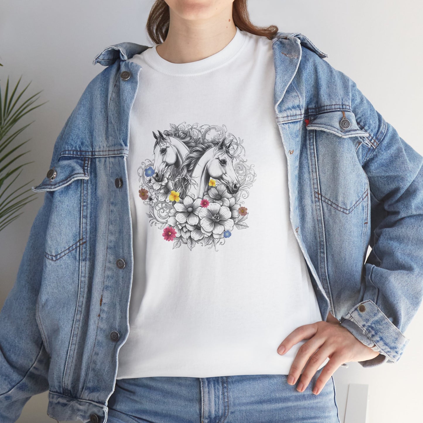 Person wearing a white t-shirt with a horse and floral design, paired with a denim jacket.