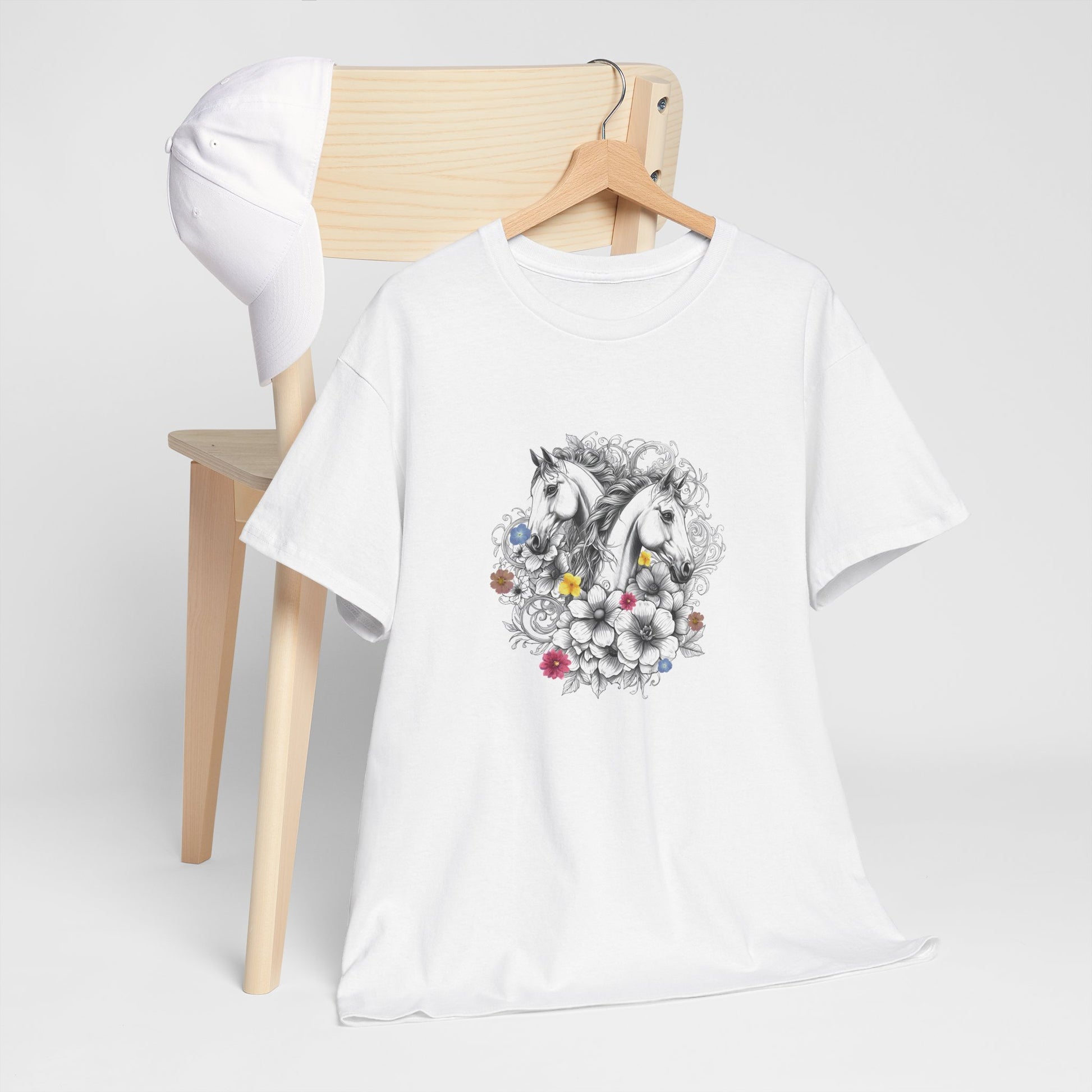 White t-shirt with a colorful design on a wooden chair against a white background