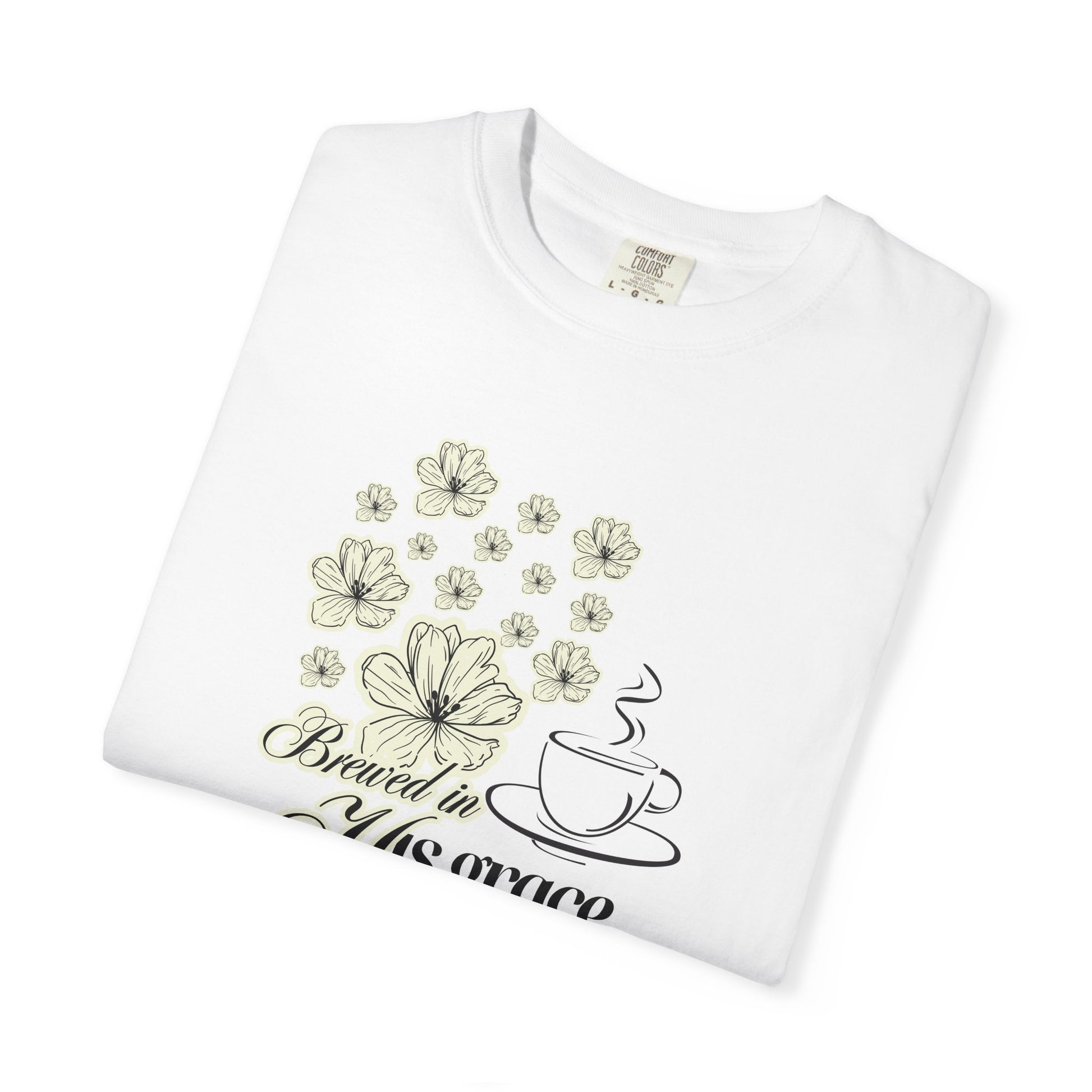 Folded white tee shirt with floral, coffee mug and brewed in his faith graphics.