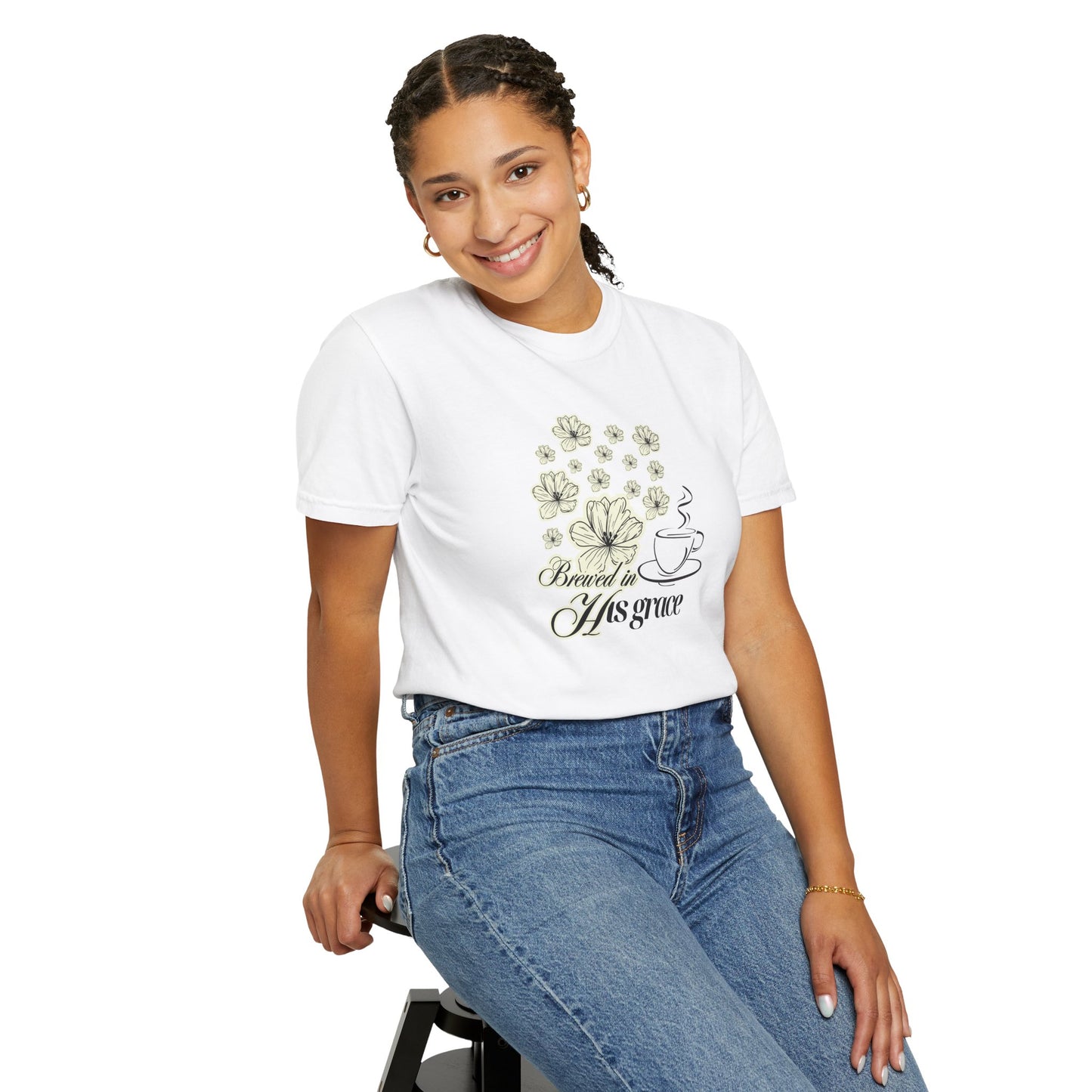 Girl sitting in a chair wearing a faith graphic tee with flowers and a hot coffee cup.