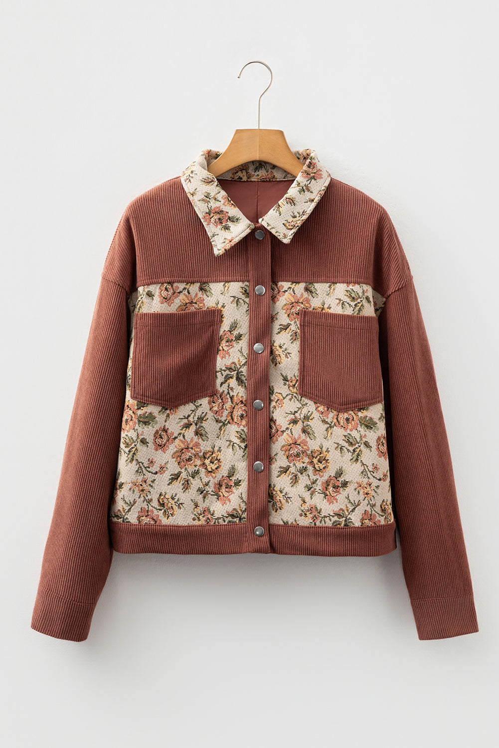 A brown ribbed floral patch work long sleeve button up jacket on a coat hanger.