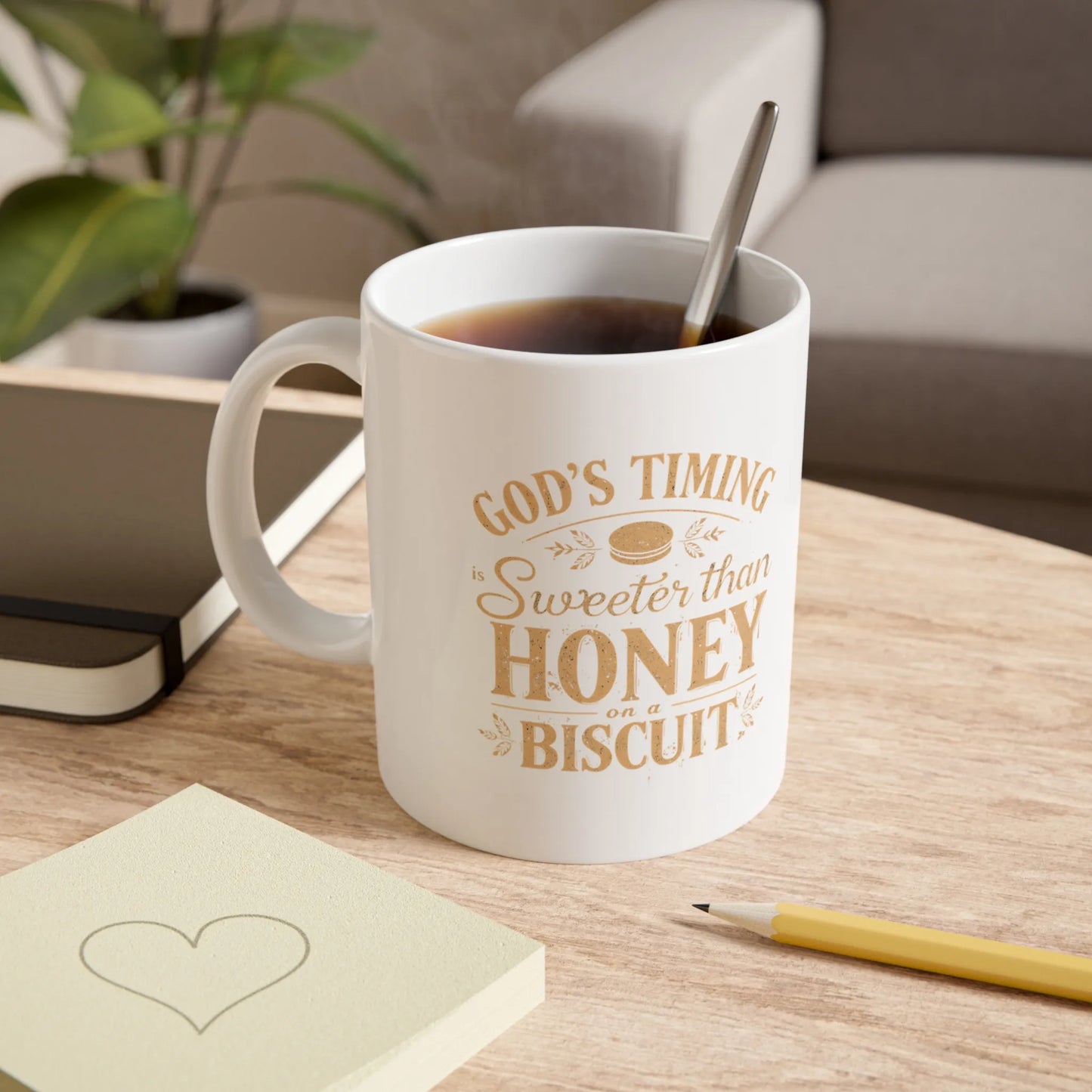 White mug with text on a wooden table with a notebook and pen.
