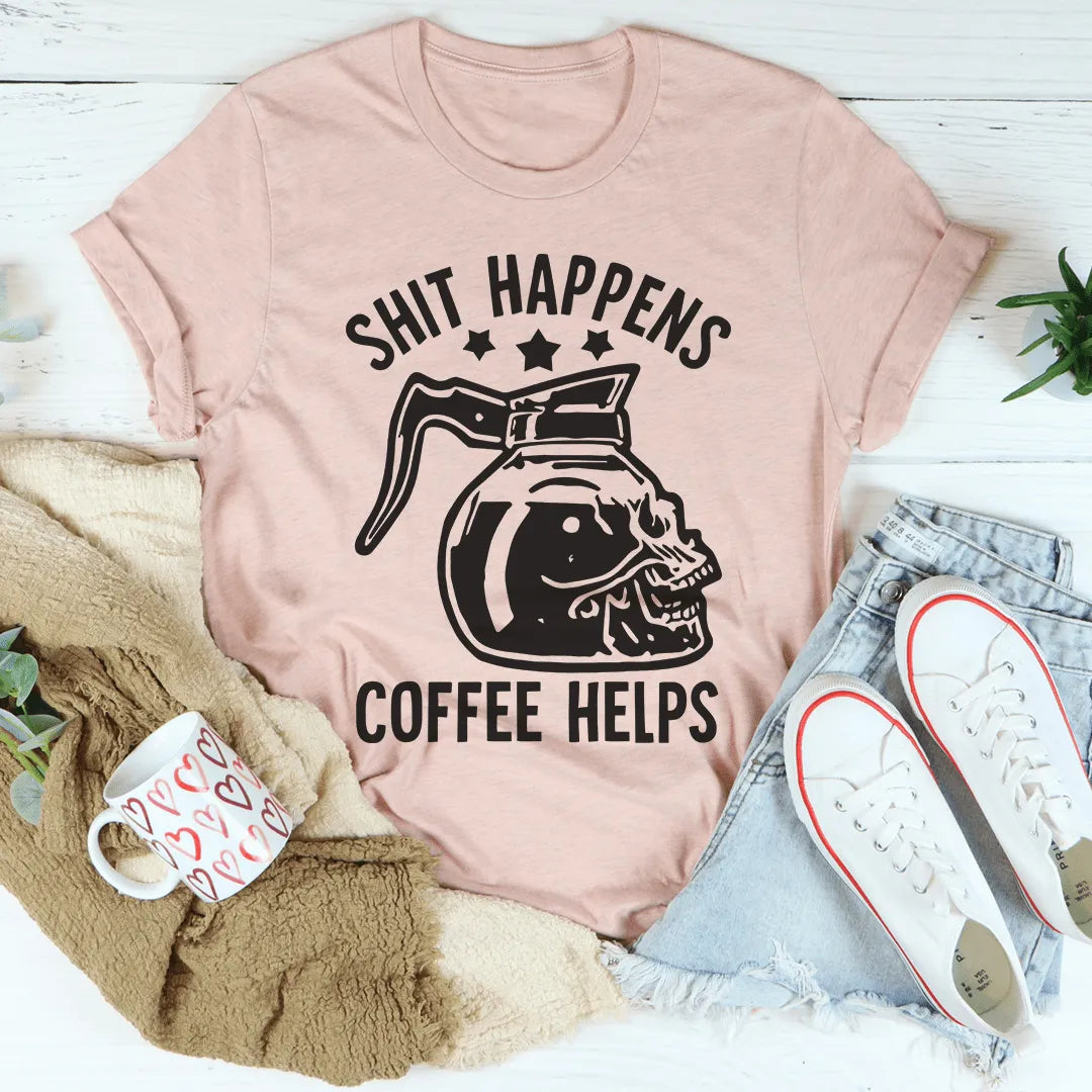 Pink t-shirt with coffee-themed graphic and text on a white surface with casual items.