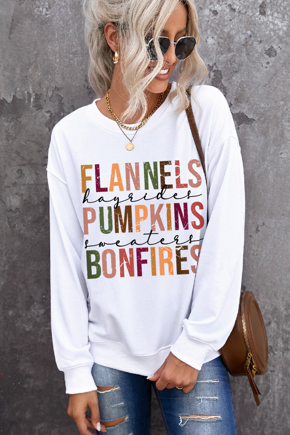 Person wearing a white sweatshirt with colorful text against a gray background