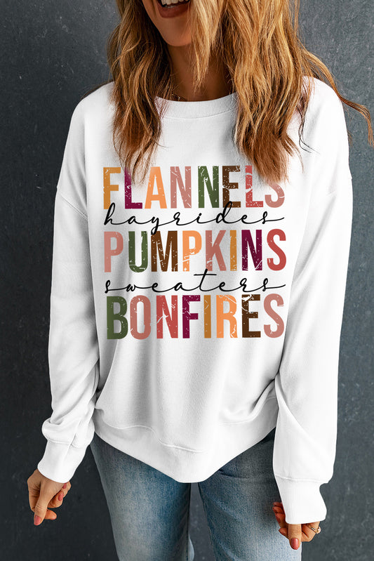 White sweatshirt with colorful text worn by a person against a dark background