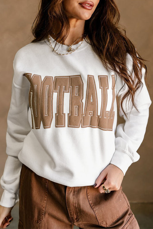 Person wearing a white sweatshirt with 'FOOTBALL' printed in brown letters against a beige background