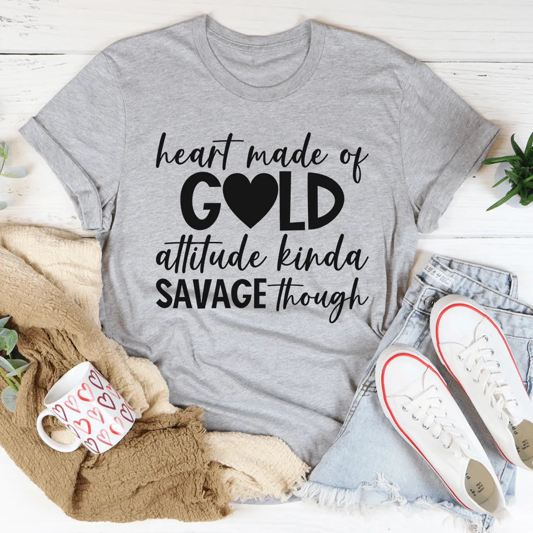 Gray t-shirt with humorous text design on a white surface with casual items around