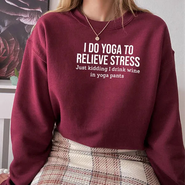 Maroon sweatshirt with humorous text worn by a person, sitting on a chair.