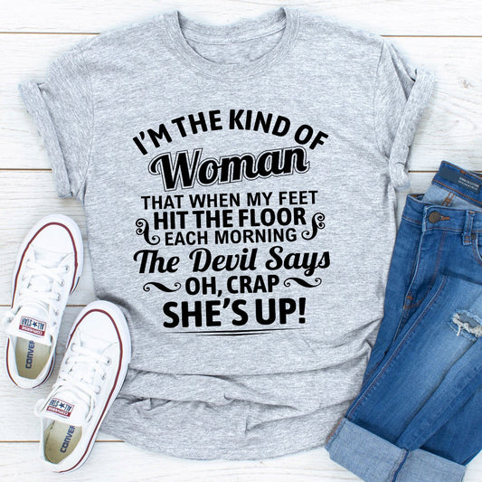 Gray t-shirt with humorous text design, paired with white sneakers and blue jeans on a light wooden surface.