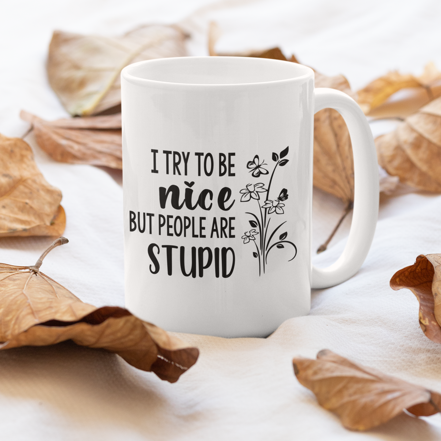 White mug with text on a light background with dried leaves
