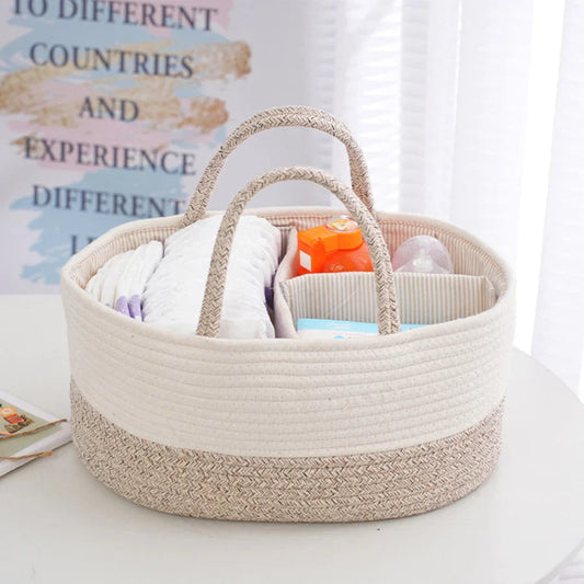 Beige woven basket with baby items on a white surface