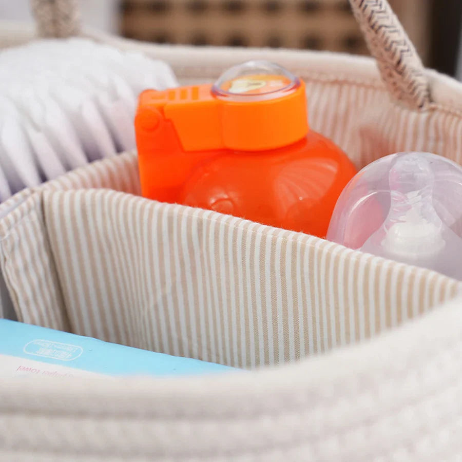 Orange bottle and pink toy in a striped basket with a blurred background