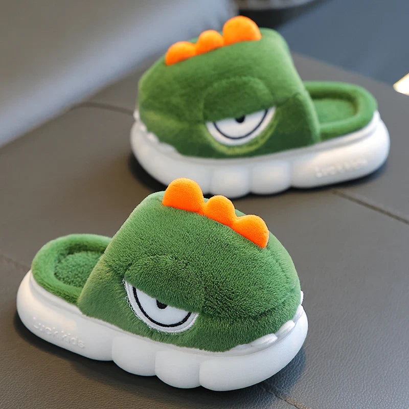 Green plush slippers with orange spikes on a gray surface