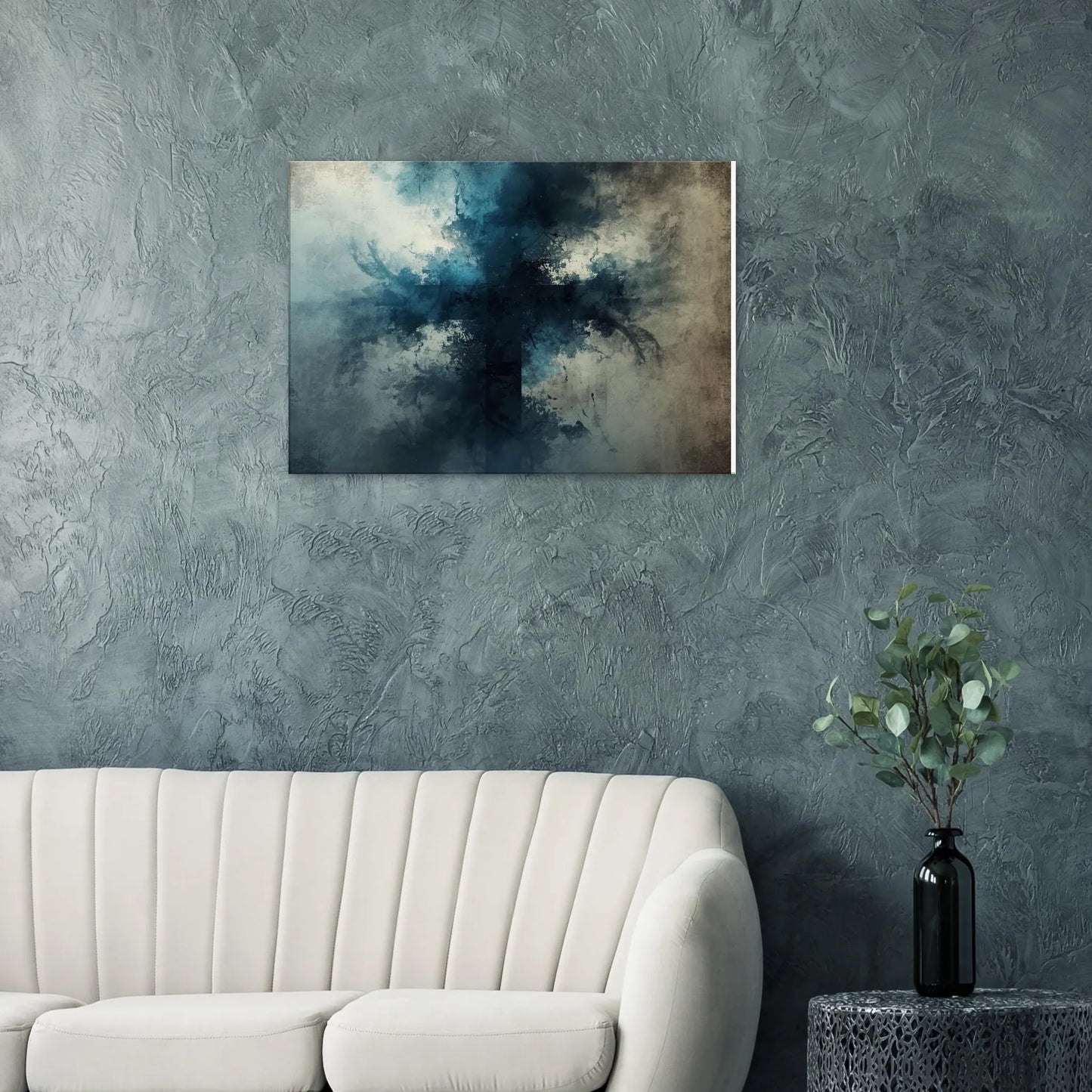 Abstract painting on a textured wall above a white sofa with a vase of greenery on a table.