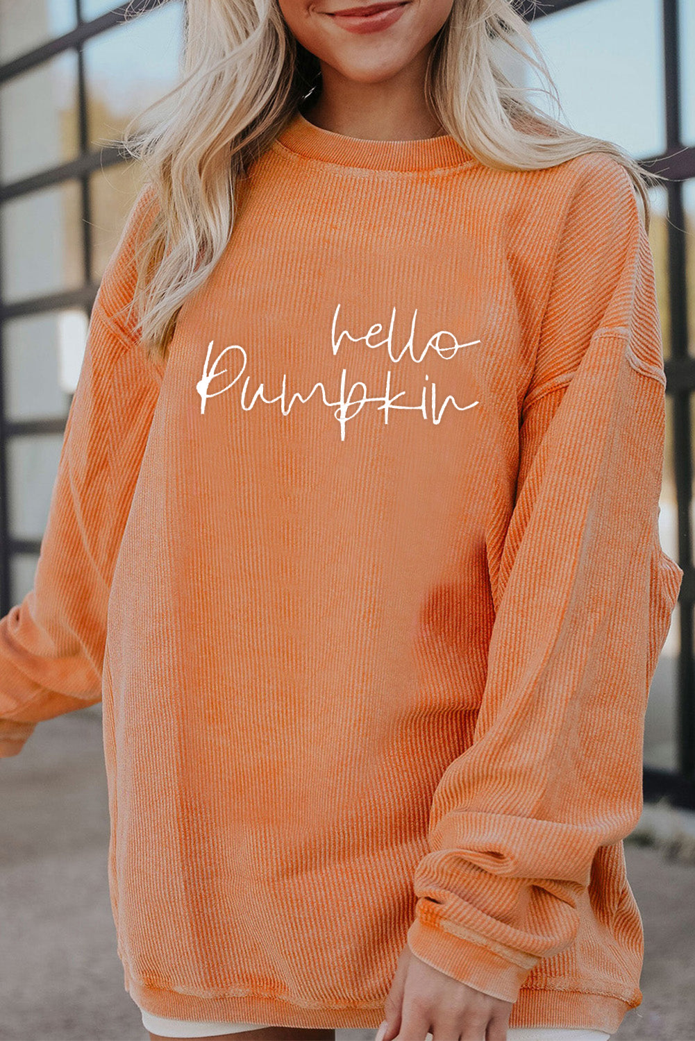 Person wearing an orange sweatshirt with 'hello pumpkin' text.