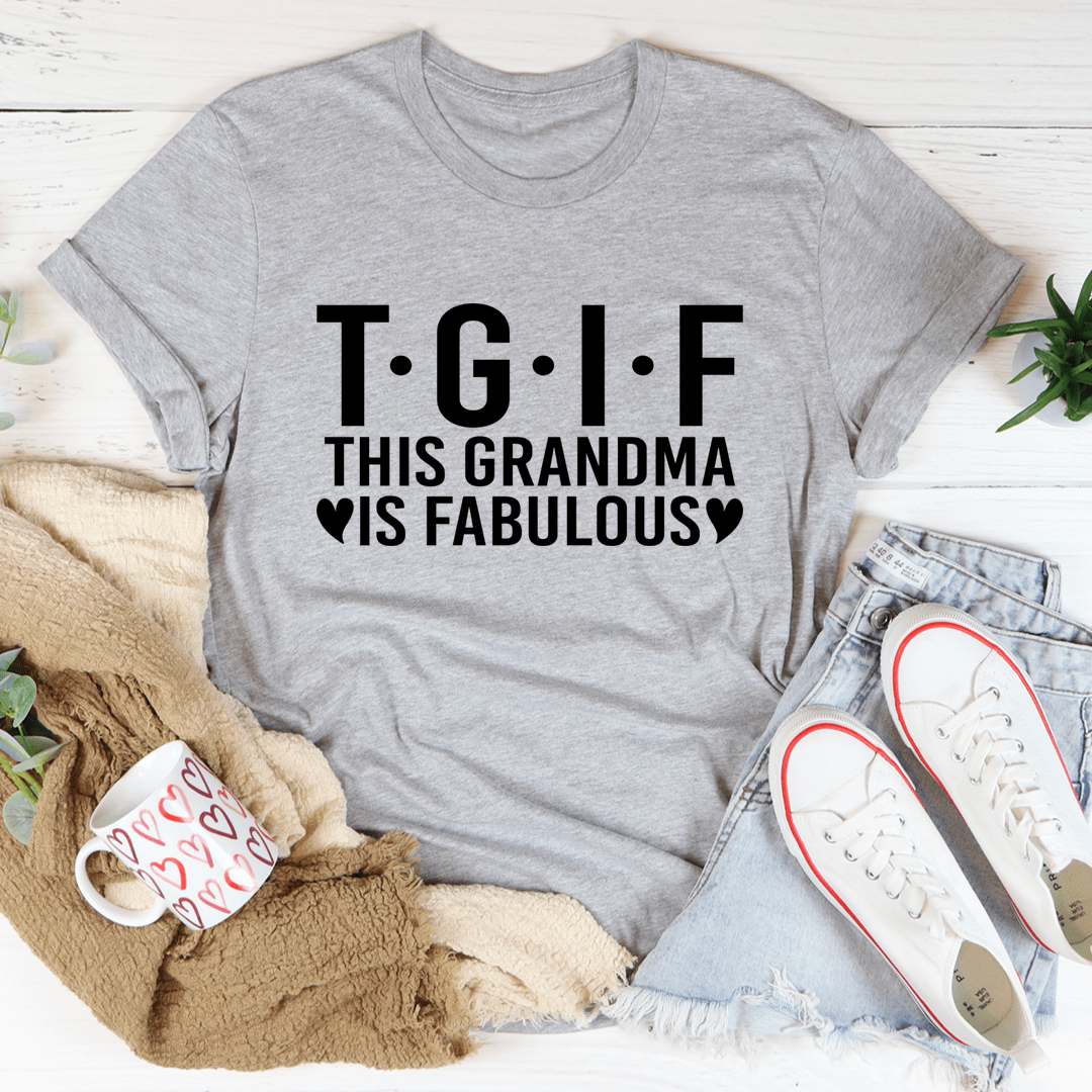 Gray t-shirt with 'T.G.I.F. This Grandma is Fabulous' text on a white surface with casual items.