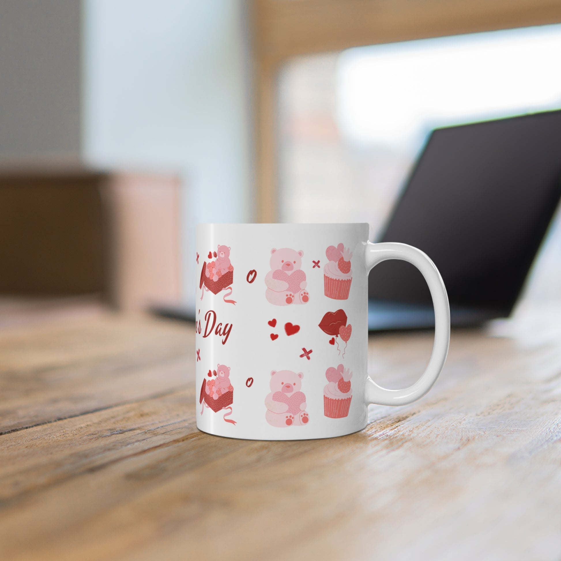 White mug with pink bear and heart designs on a wooden surface