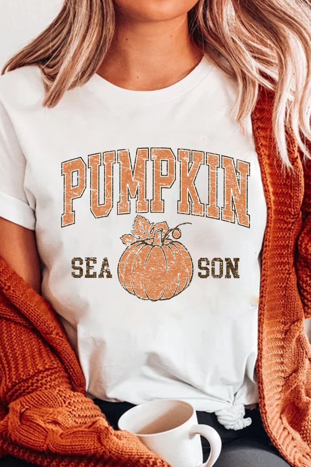 Person wearing a white t-shirt with 'Pumpkin Season' graphic design.