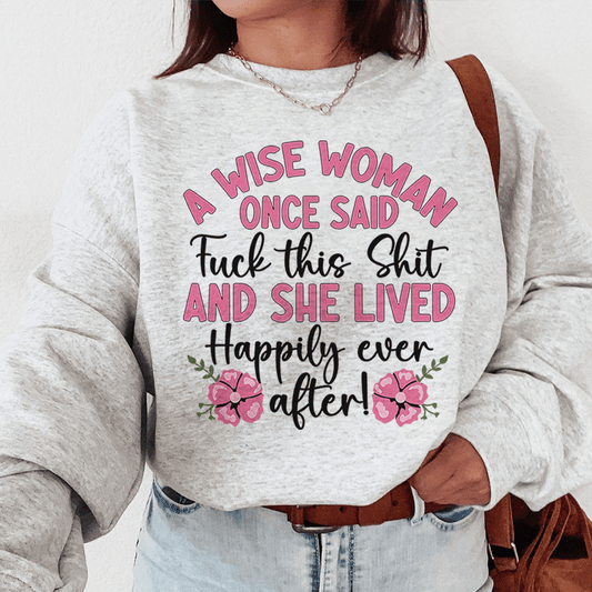 Person wearing a sweatshirt with a humorous quote in pink and black text.